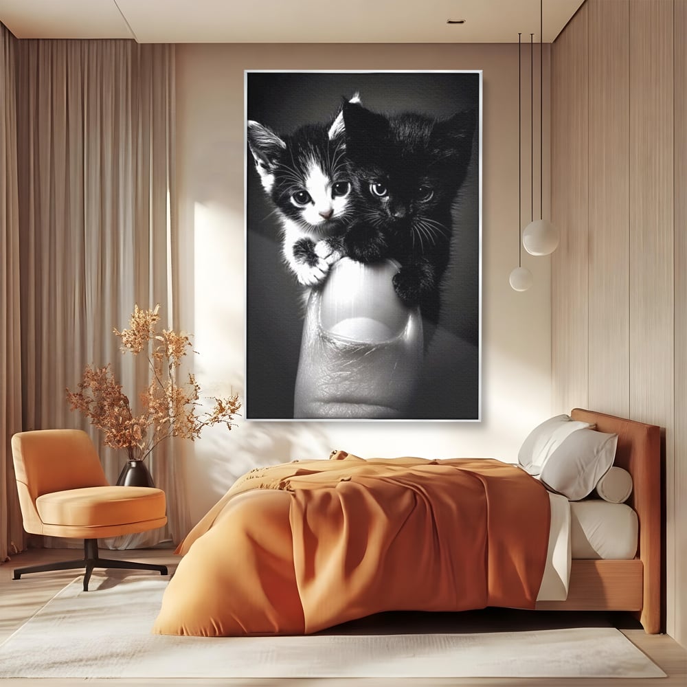 Tablou canvas cu tablou canvas cu doi pisoi mici agatati de un deget, in rama de aluminiu argintiu, pe perete intr-un dormitor